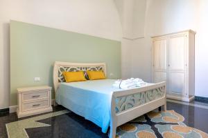 una camera da letto con letto con lenzuola blu e cuscini gialli di Gma Home Primo Piano a Pulsano