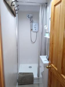 a white bathroom with a shower and a sink at Rose Lea, Beautiful Seaside Home in Staithes