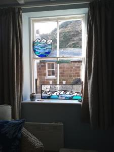 a window with a bench in front of a window at Rose Lea, Beautiful Seaside Home in Staithes