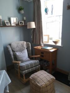 a room with a chair and a desk and a window at Rose Lea, Beautiful Seaside Home in Staithes