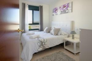 una camera da letto con un letto bianco e una finestra di Duplex vista mar a Playa Blanca