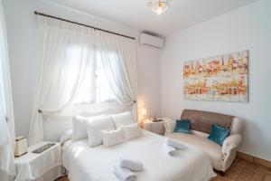 ein Schlafzimmer mit zwei Betten und einer Couch und einem Fenster in der Unterkunft Casa Rural Pozo Viejo in Marchena + 30 Fotos