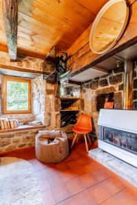 a living room with a stone fireplace in a cabin at Cocon avec jacuzzi in Labastide-de-Juvinas