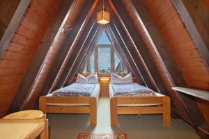 deux lits dans une chambre avec une grande fenêtre dans l'établissement Nurdach-Haus Typ 7, à Immenstaad am Bodensee