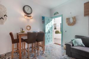 ein Esszimmer mit einem Tisch und einer Uhr an der Wand in der Unterkunft Casa Gecko in Benalmádena