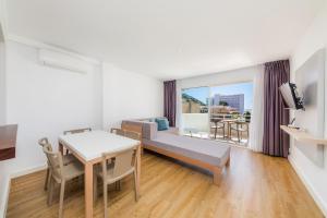 a living room with a couch and a table with a dining room at Apartament Massanet 2c in Canyamel