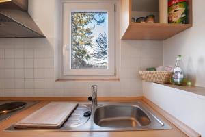 Una encimera de cocina con un fregadero y una ventana. en Birkethof Studio, en Mickhausen