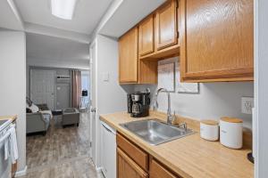 a kitchen with wooden cabinets and a sink at Stylish 1st Flr 1Bed Condo-Close to Downtown Dover in Dover +15 photos