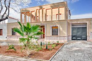 a house with a palm tree in front of it at Ca Margarita in Benegida