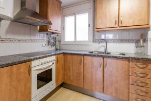 eine Küche mit Holzschränken und einer Spüle in der Unterkunft Apartamento Coral in Tossa de Mar