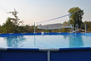 a large swimming pool with a volleyball net at Ferienatelier im Haus Ginkgo in Zempow