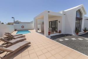 una villa con piscina y tumbonas en Casa Angelita Y Pablo, en Playa Blanca