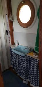 Un baño con lavabo y ventana redonda. en Urgemütliches Bungalow am See, en Schwielochsee 2 fotos más
