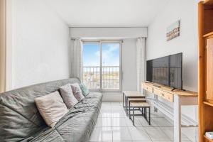 a living room with a couch and a flat screen tv at Évasion Océane - Vue mer, Soulac in Soulac-sur-Mer