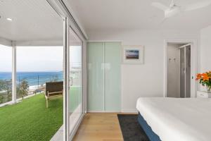 a bedroom with a bed and a view of the ocean at Flatrock Penthouse Ulladulla in Ulladulla +27 photos