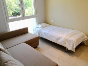 a small bedroom with a bed and a window at Turó de Tjelle in L'Ampolla +14 photos