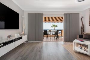 ein Wohnzimmer mit einem TV und einem Esszimmer in der Unterkunft Apartamento junto al Mar in Araya