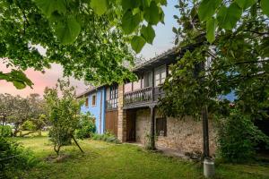 a blue building with a balcony on the side of it at La Quintana de la Foncalada in El Cabritón
