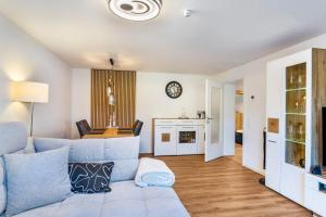 a living room with a blue couch and a kitchen at Ferienwohnung Nordhelle in Herscheid
