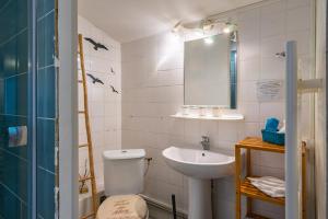 Un baño con lavabo, inodoro y espejo. en Le Logis Des Lauriers Roses, en Marennes