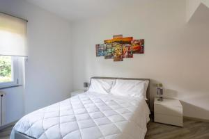 a bedroom with a white bed and a painting on the wall at Rocca Lake House in Angera