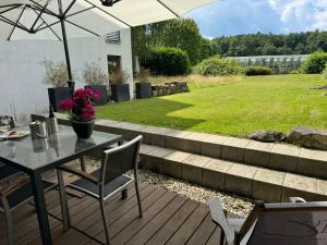 a patio with a table and chairs and an umbrella at Ruhe und Living in Unterraderach