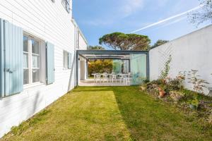 a white house with a patio and a yard at Les Oyats in La Couarde-sur-Mer