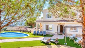 a villa with a swimming pool and a house at Costacabana - Villa Ibiza in Lloret de Mar