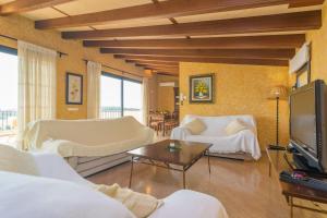 Una sala de estar con muebles blancos y un televisor. en Can Nadal - Adults Only, en Sineu