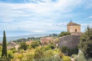 un bâtiment au sommet d'une colline avec une tour dans l'établissement Vecchio Forno, à Puntalazzo