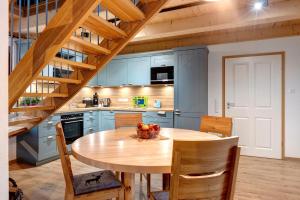 a kitchen with blue cabinets and a wooden table at Gästehaus Kornspeicher Untere Mühle in Königsfeld im Schwarzwald