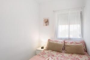 a bedroom with a pink bed with a window at Un descanso 2-1 in Playa del Ingles