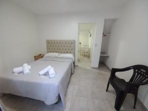 une chambre d'hôtel avec un lit et une chaise dans l'établissement Hospedaje LH Planta Baja E a 15 min del Aeropuerto de Ezeiza, à Ezeiza