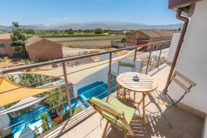 ein Balkon eines Hauses mit einem Tisch und Stühlen in der Unterkunft Apartamentos la Vega de Granada in Ambroz
