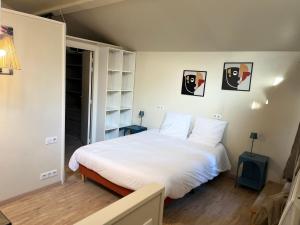 een slaapkamer met een groot bed met witte lakens bij Magnifique villa avec piscine pour2 à 13 personnes in Bourg-en-Bresse