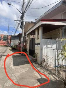 MetroNOOK Lucena Cozy Loft Type, AC, WI-FI,Netflix,Prime Video في لوسينا: خرطوم أحمر على جانب المنزل