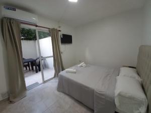 une chambre avec un lit et une porte coulissante en verre dans l'établissement Hospedaje LH Planta Baja E a 15 min del Aeropuerto de Ezeiza, à Ezeiza