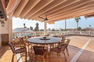 a patio with a table and chairs on a deck at Lola Sunset Place Heated Pool in San Miguel de Abona