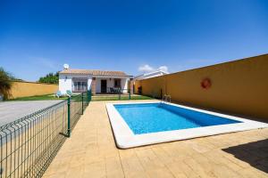 a swimming pool in the backyard of a house at Luisa 1 in Conil de la Frontera