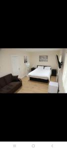 a bedroom with a bed and a couch at BUDGET Twin Double Rooms in Thamesmead