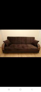 a brown leather couch with pillows on the floor at BUDGET Twin Double Rooms in Thamesmead +3 photos
