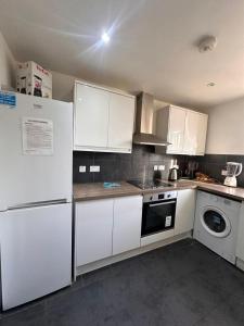 a kitchen with white appliances and white cabinets at BUDGET Twin Double Rooms in Thamesmead