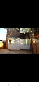 a garage with two white doors and a building at BUDGET Twin Double Rooms in Thamesmead