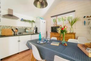 a kitchen with a table with a blue table cloth at Gîte La Marinière - La Corne d'Or in Plurien