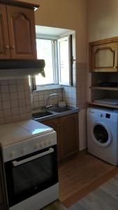 eine Küche mit Waschmaschine und Spüle in der Unterkunft Traditional House in Rífion