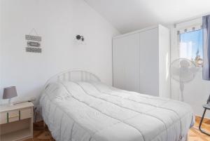 a white bedroom with a bed and a desk and a window at Gîte Le 878 in Roquefort-des-Corbières +19 photos