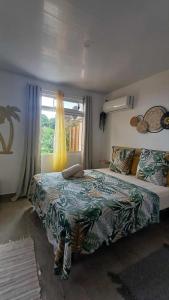 a bedroom with a large bed and a window at Fare tenuiarii " fare knt" in Ataiti