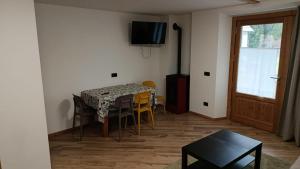 a dining room with a table and chairs and a television at Appartamento Via Livigno in Isolaccia
