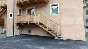 a wooden staircase on the side of a building at Appartamento Via Livigno in Isolaccia