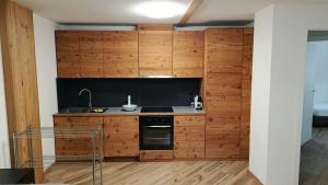 a kitchen with wooden cabinets and a stove at Appartamento Via Livigno in Isolaccia